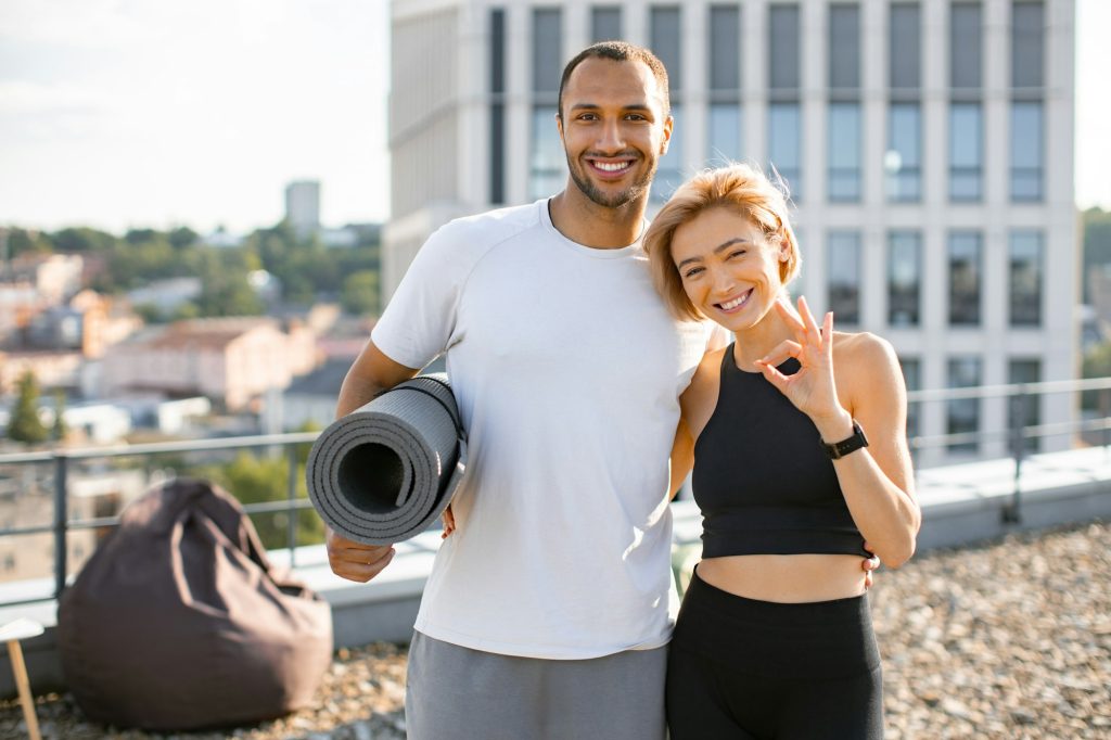 Portrait of happy family doing sports in summer against urban landscape.