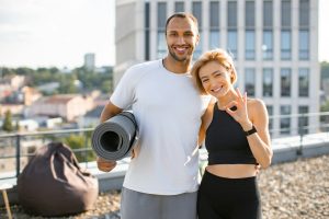 Portrait of happy family doing sports in summer against urban landscape.